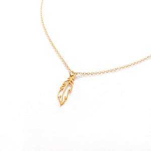 Gold Feather charm on a fine necklace